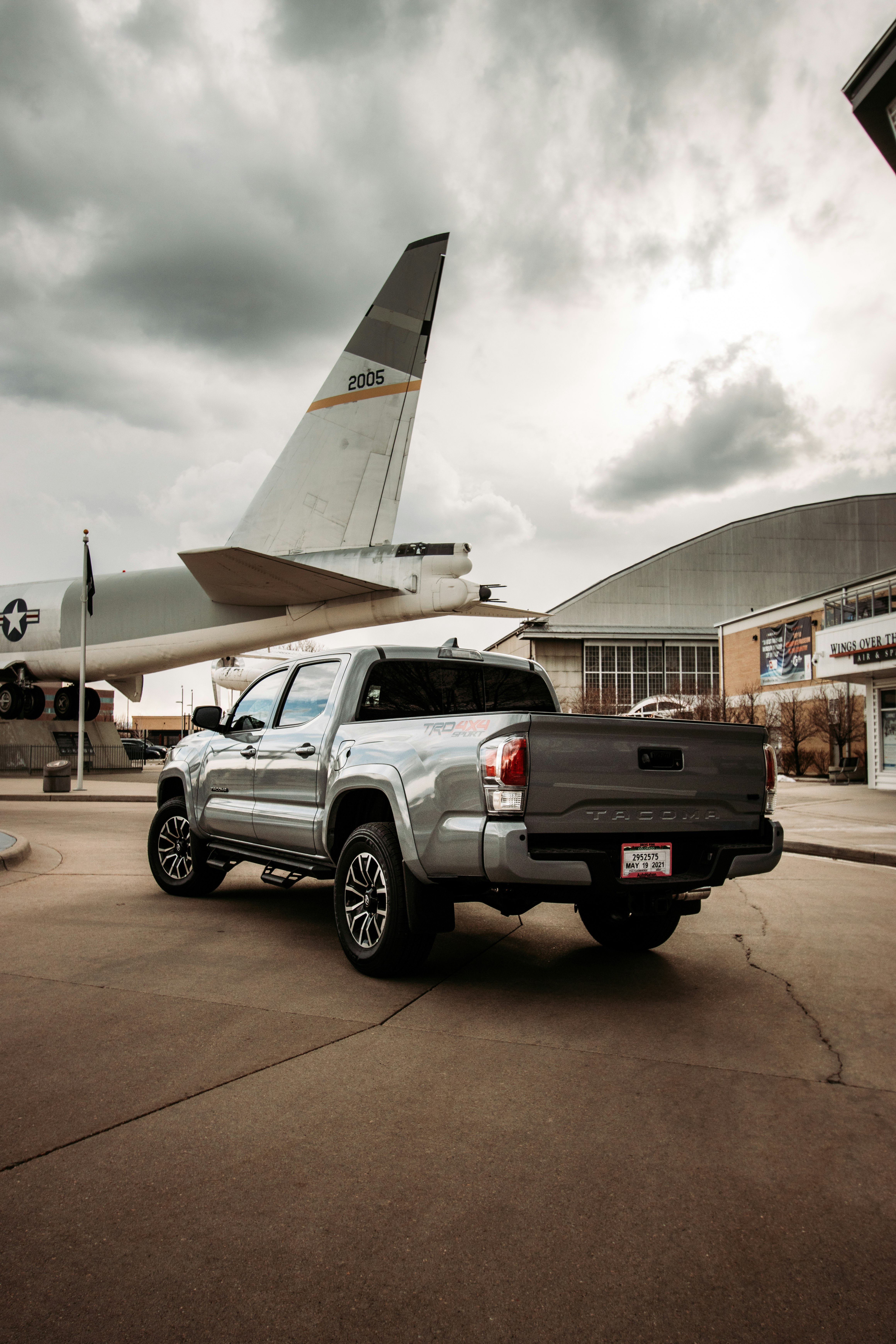 white crew cab pickup truck parked near white airplane